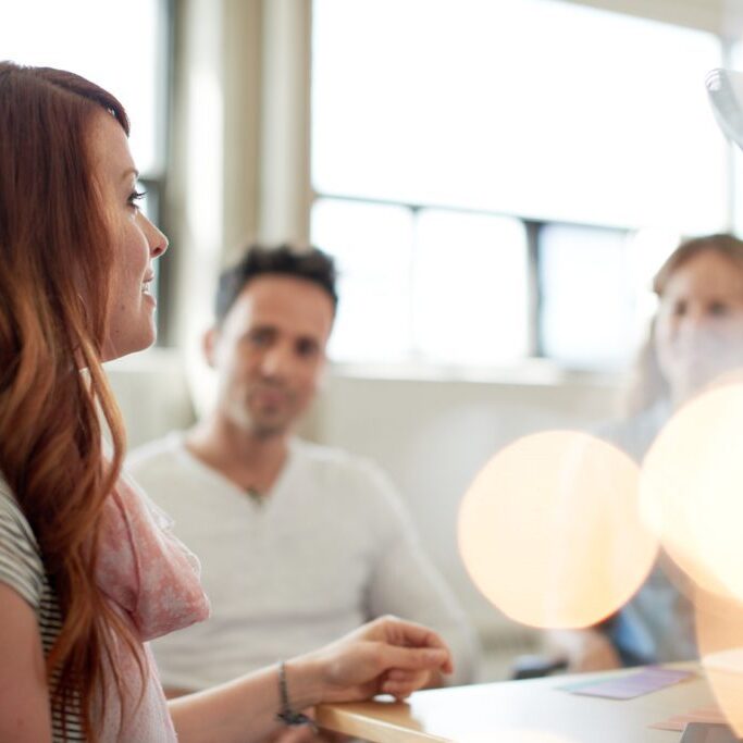 Candid picture of a business team collaborating. Filtered serie with light flares, bokeh  and warm sunny tones.